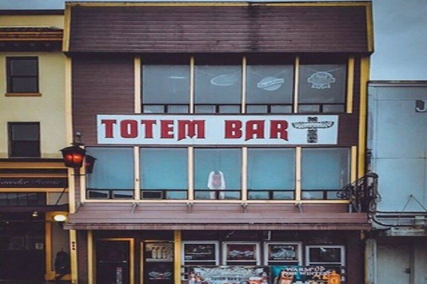 En bygning med et skilt, der viser 'TOTEM BAR' over indgangen. 3