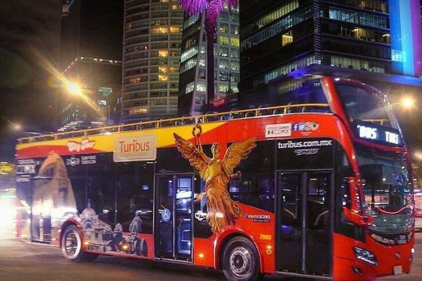 A red double-decker bus with a golden eagle advertisement, branded with 'Turbus,' on a city street at night. 5