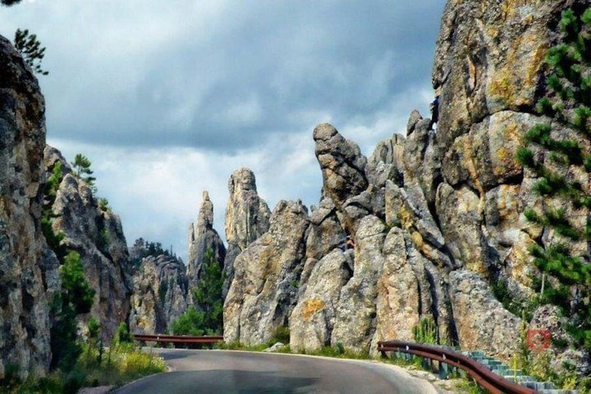 A winding road through rocky terrain with prominent rock formations and sparse vegetation. 5