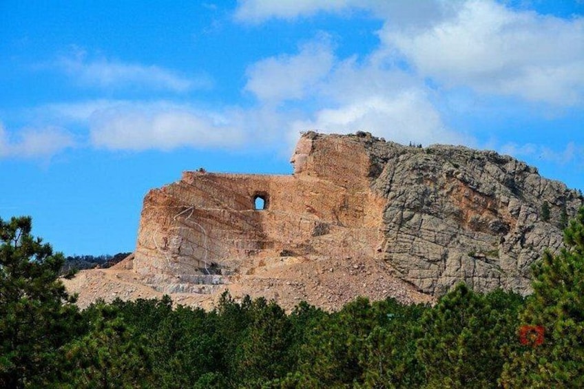 Une falaise rocheuse avec une entrée de grotte et un feuillage vert et dense à sa base. 4