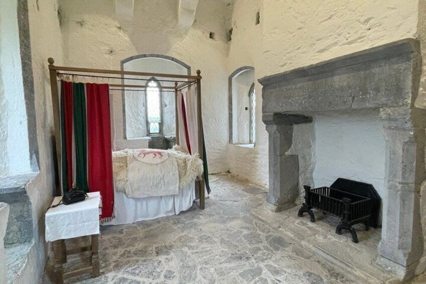 Una stanza con un letto a baldacchino, un camino e pareti in pietra. 4