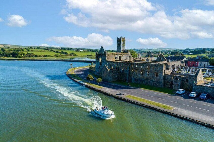 Un barco en un río, un castillo y una carretera con coches. 5