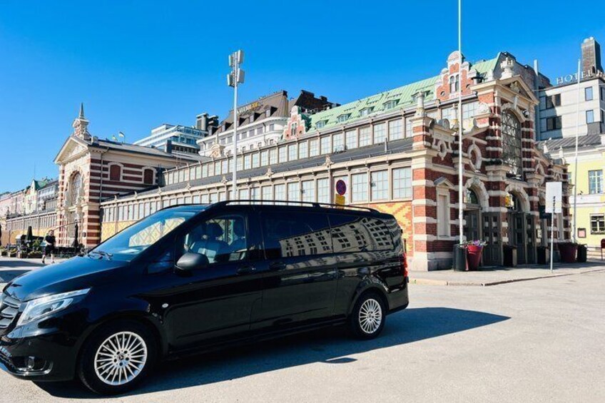 Una camioneta negra estacionada frente a un edificio histórico de arquitectura ornamentada. 1