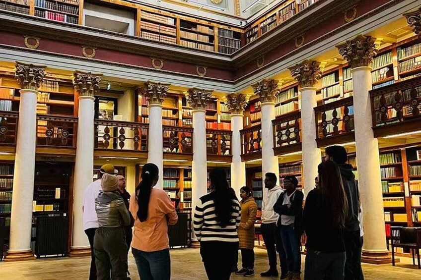 Een bibliotheekinterieur met mensen die staan en boeken lezen. 3