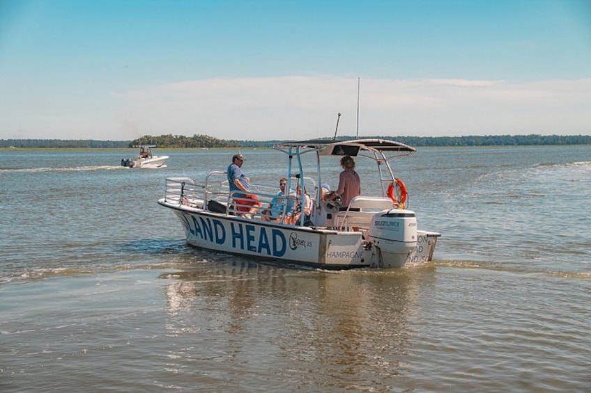 Een boot genaamd LAND HEAD op het water, met een andere boot op de achtergrond. 2