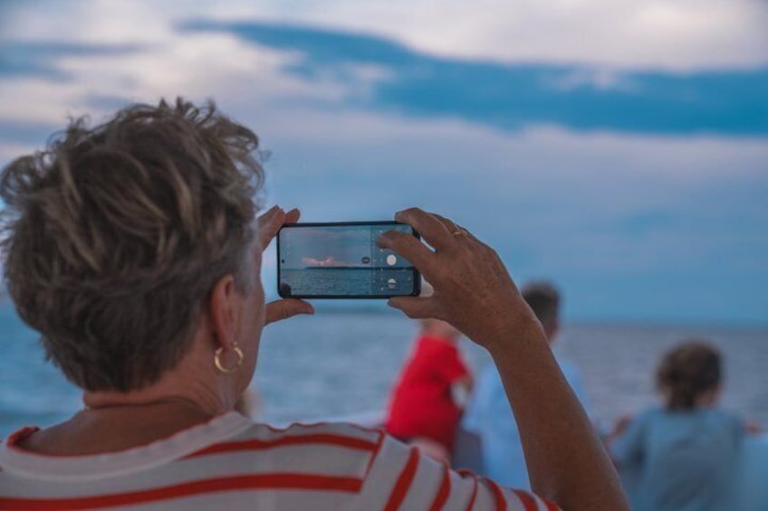 En person tager et billede af havet med en smartphone. 4