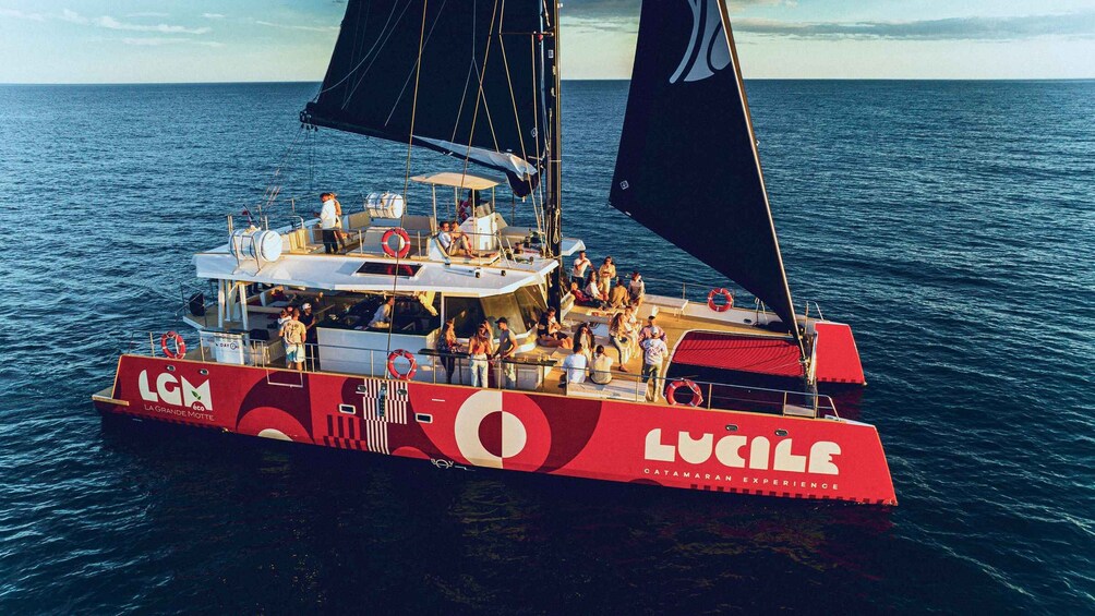 A red and white boat named 'LUCILE' with 'LGM' and 'LA GRANDE MOTTE' logos, sailing on the ocean. 2