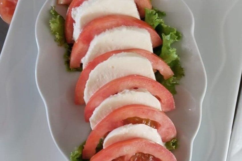 A plate with sliced tomatoes and mozzarella cheese. 4