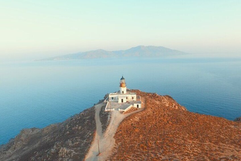 Un phare côtier, situé sur un promontoire rocheux, offre une vue dégagée sur la mer et le lointain horizon terrestre. 2