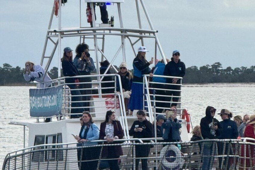 A group of people on a boat with a sign that reads 'BAYBAYBOATS.COM'. 1