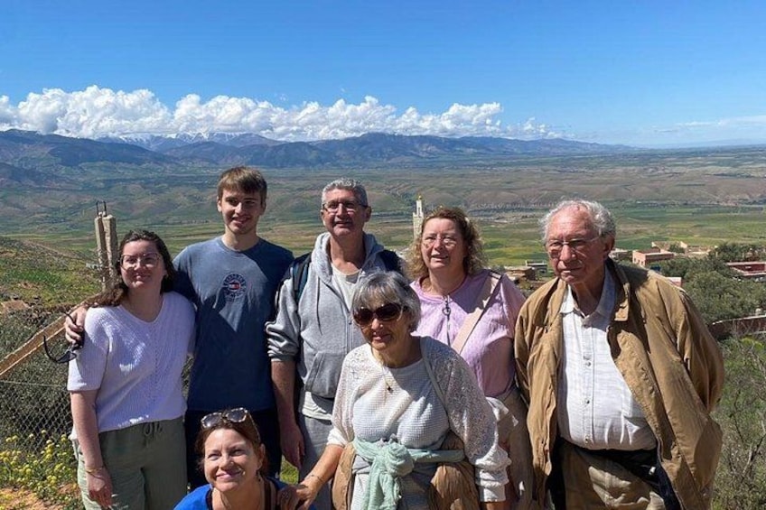 A group of people standing on a hill with a mountainous landscape in the background. 2