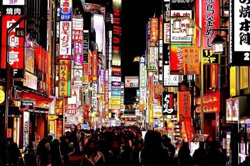 Une rue animée en plein centre-ville, de nuit, avec de nombreuses enseignes et panneaux publicitaires illuminés. 5
