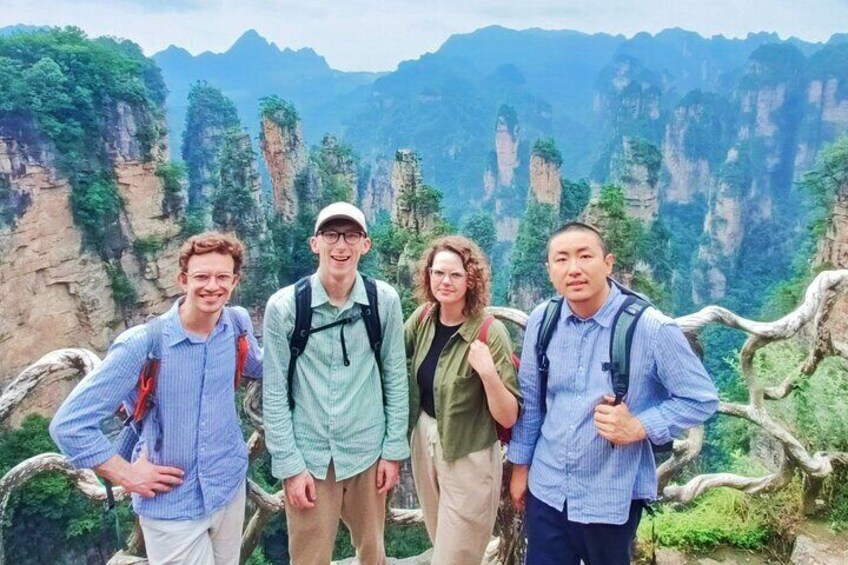 Un grupo de cuatro personas de pie sobre un afloramiento rocoso, con un paisaje montañoso al fondo. 1