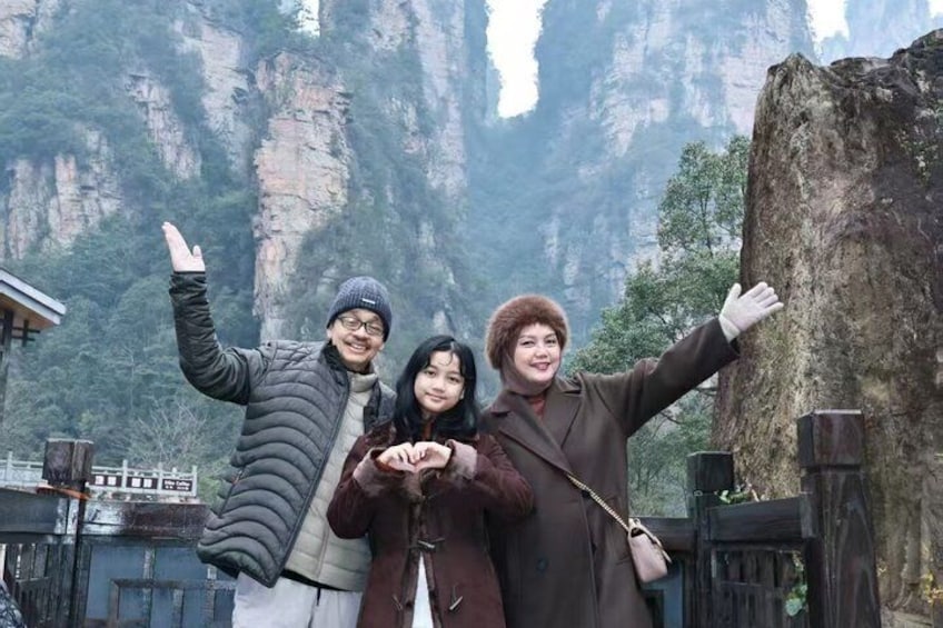 Un grupo de personas posando junto a una gran formación rocosa en una zona montañosa. 5