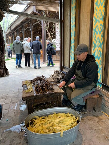 A person processing plant material at a market stall. 2
