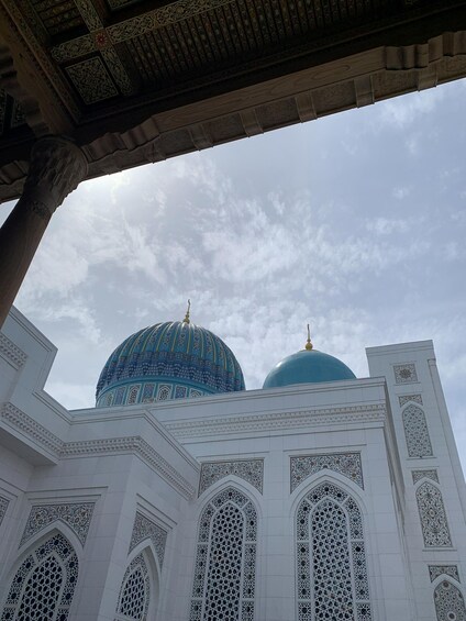 A mosque with intricate white and blue domes and detailed geometric patterns. 5