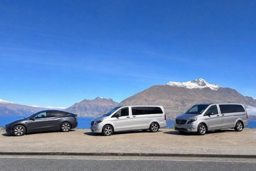 Three vehicles parked on a road with a mountainous background. 2