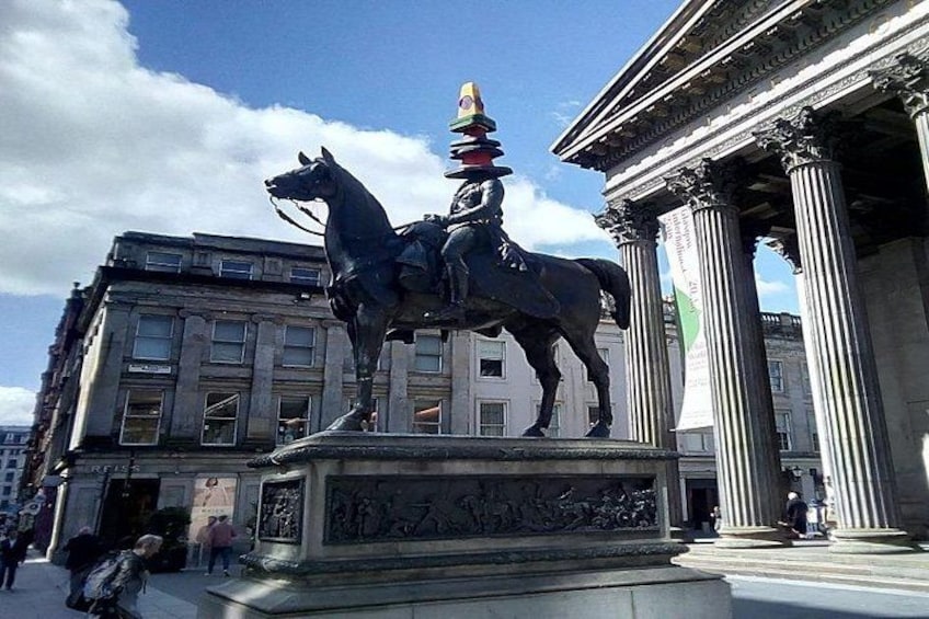A statue of a man on a horse in front of a classical building with columns. 4