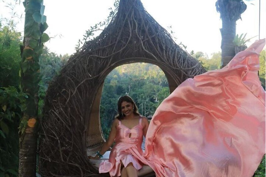 A person sitting in a circular wooden structure surrounded by greenery. 2