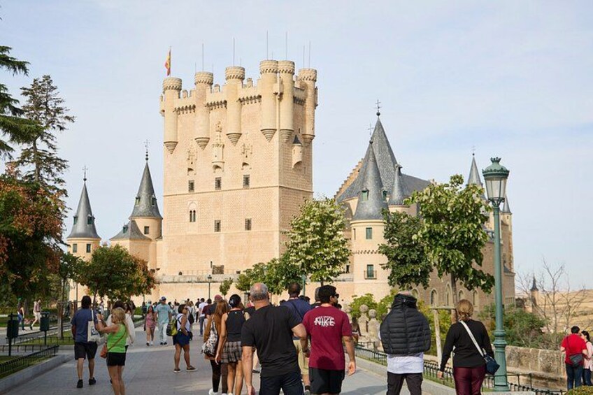Un castello con diverse torri e una folla di persone che passeggiano davanti. 2