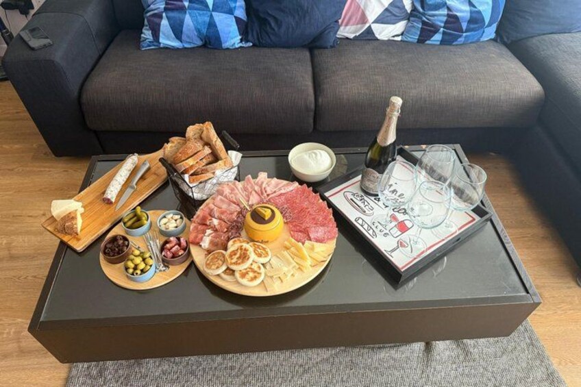 En charkuteritallrik med olika sorters kött, ostar och frukter, upplagd på ett bord. 2