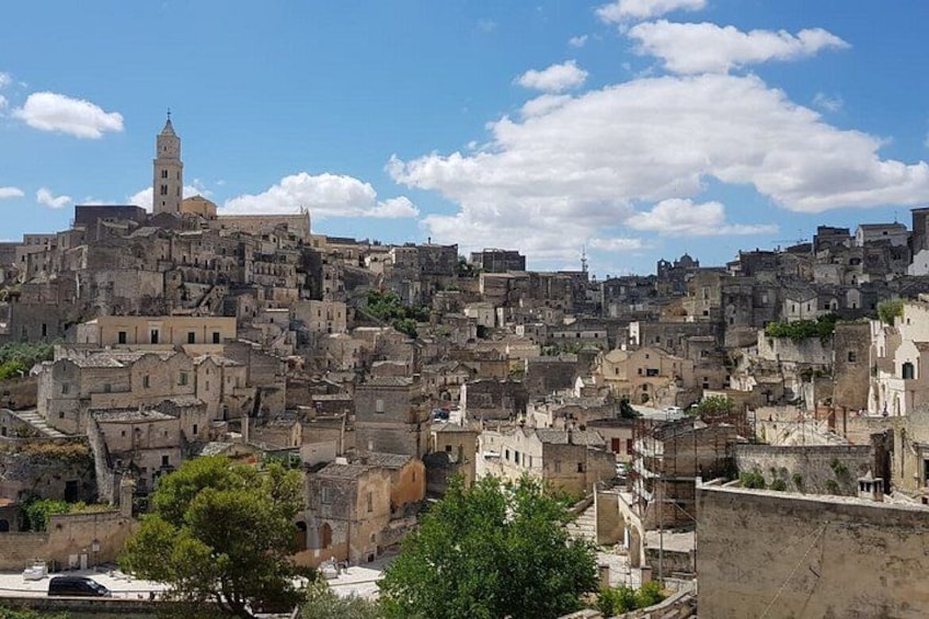 Una cittadina storica affollata, caratterizzata da un campanile imponente, strade acciottolate e un mix di edifici antichi e moderni. 2