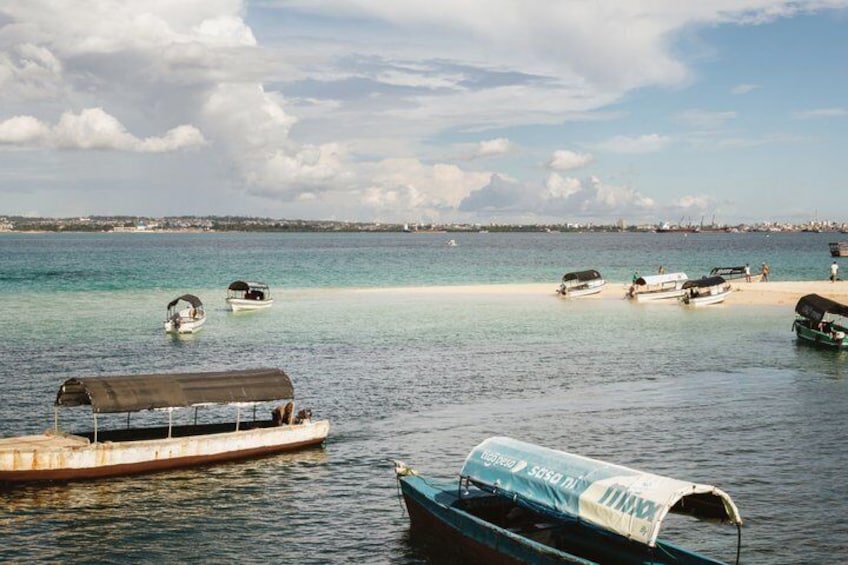 Paesaggio costiero con barche ancorate vicino a una spiaggia sabbiosa e acque calme. 4