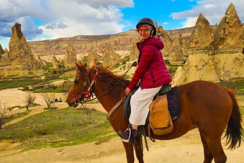 A person riding a horse in a rocky landscape with distinctive rock formations. 3