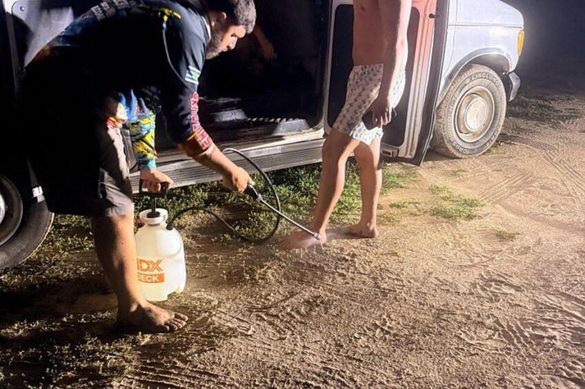 Two people using a sprayer on a vehicle. 5