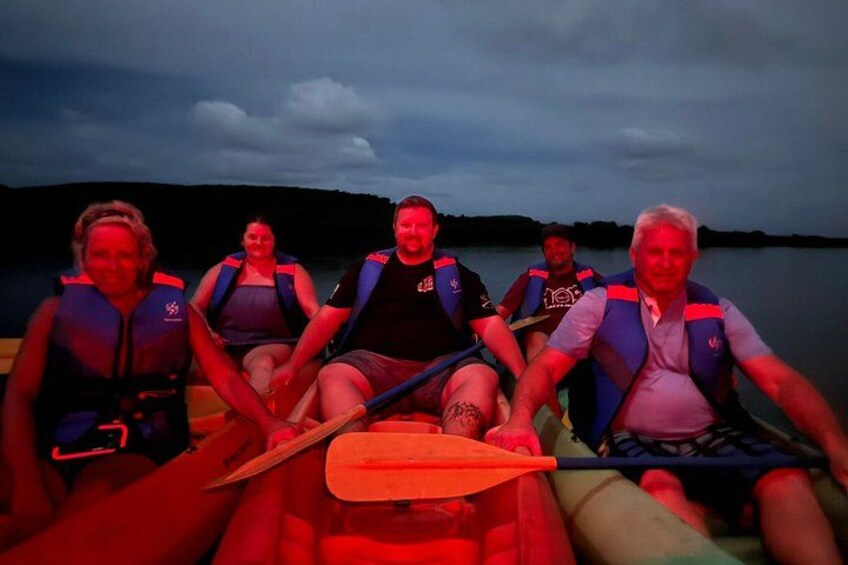 A group of people in a canoe on a calm body of water. 3