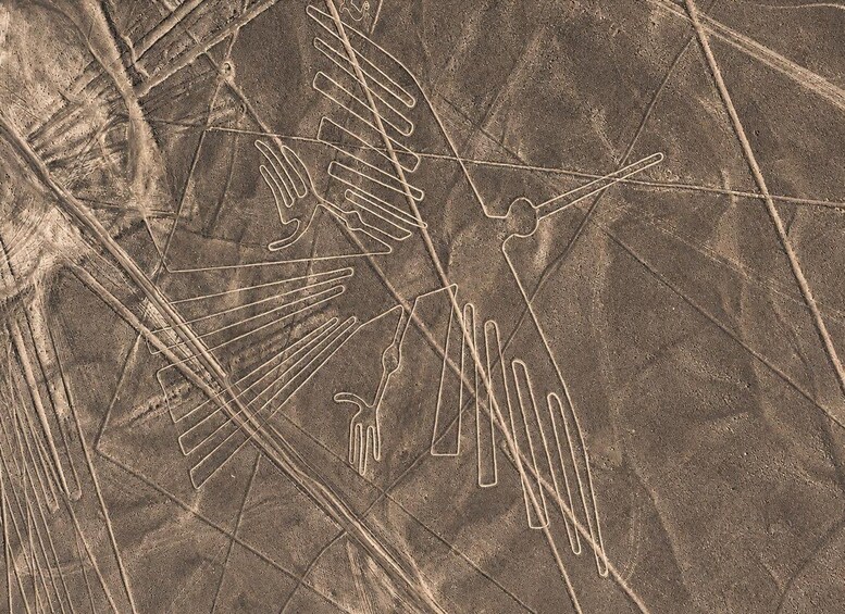 A desert landscape with linear patterns, possibly from wind erosion or human activity. 2
