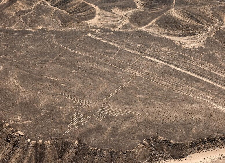 A desert landscape with linear patterns etched into the ground, possibly from vehicles or machinery. 5