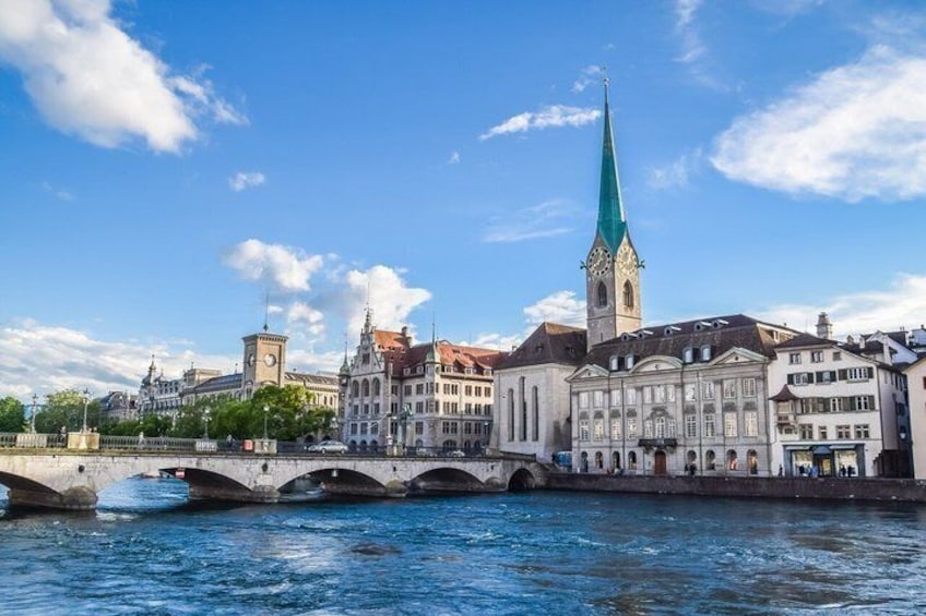 A river with a bridge, historic buildings, and a church with a spire. 3