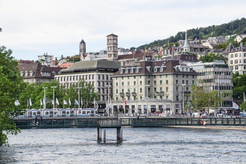 A riverside cityscape with historic buildings, a bridge, and a boat dock. 5