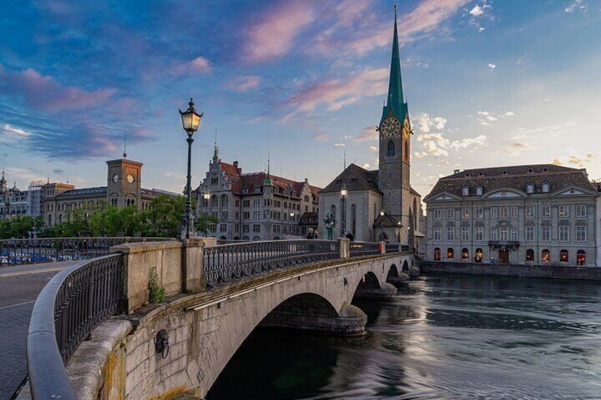 A stone bridge over a river, a clock tower, and historic buildings. 1
