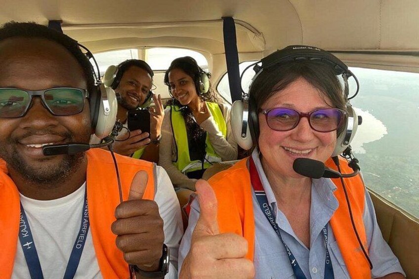Drie personen in een cabine, gekleed in veiligheidshesjes en headsets. 3