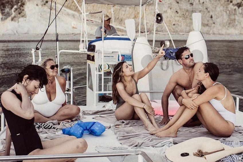 Un grupo de personas en un bote, con una costa rocosa al fondo. 2