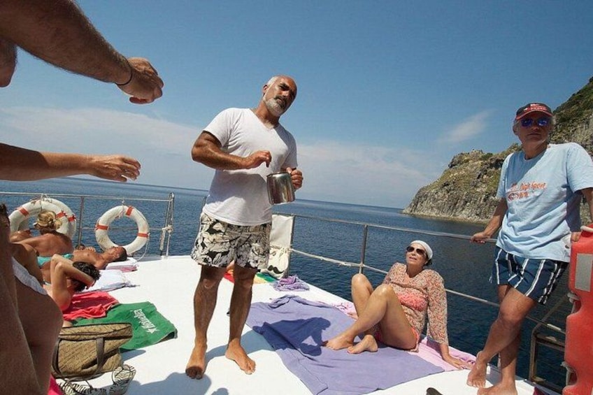 A group of people on a boat with a rocky coastline in the background. 3