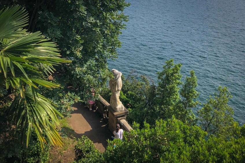 A statue in a park with a body of water in the background. 2