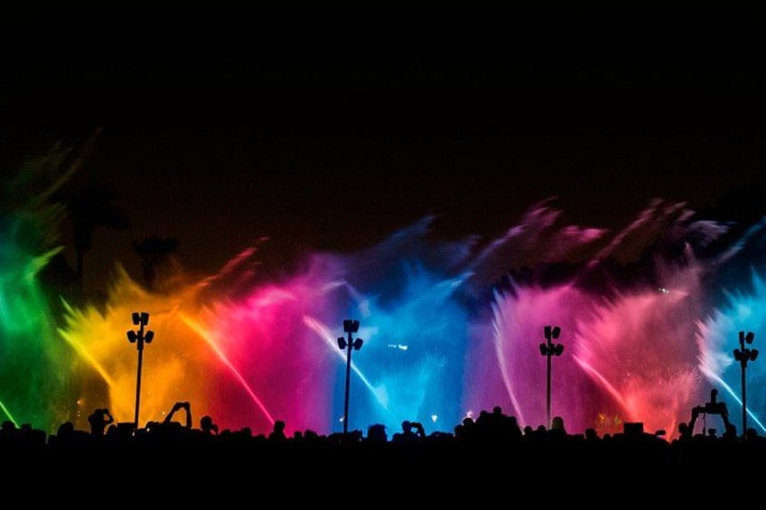 A night scene with colorful light displays and silhouettes of people. 5