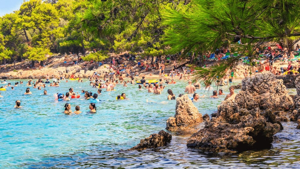 A crowded beach with people swimming and enjoying the water. 3