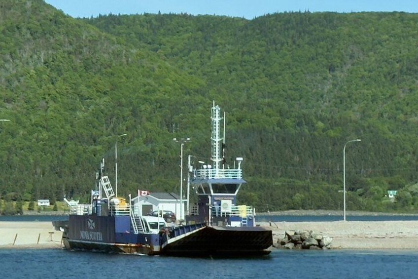 Ein großes Schiff liegt in einem Hafen vor einer Bergkulisse festgemacht. 4