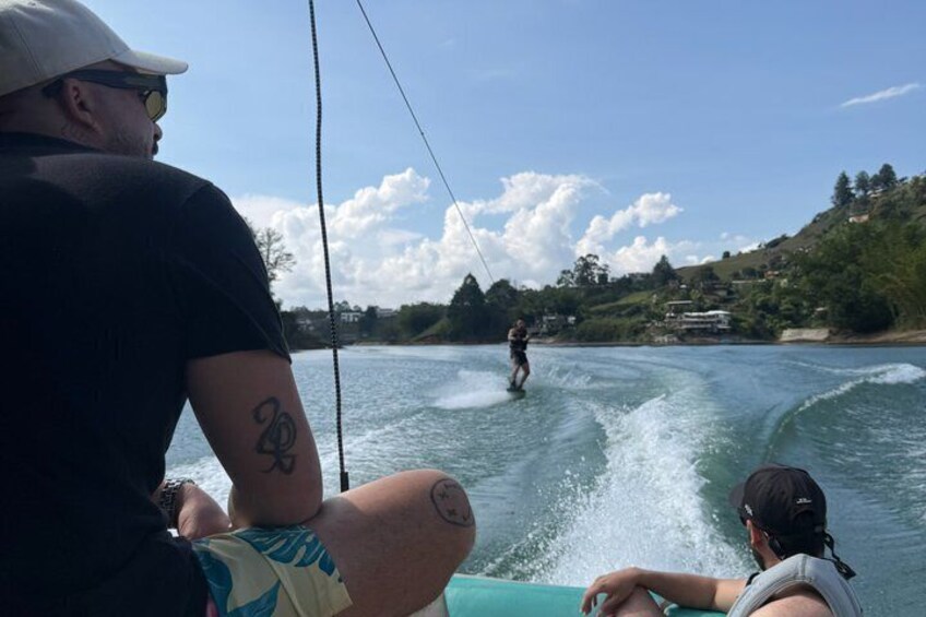 Un'attività di wakeboard su un corpo d'acqua, con una persona che fa wakeboard e un'altra su una barca. 1