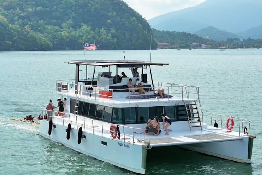 Un bote blanco con gente a bordo, un flotador salvavidas y una bandera. 4