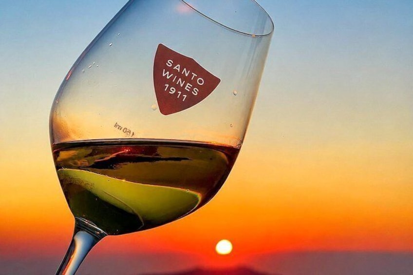 Ett glas vin med en solnedgång i bakgrunden. 1