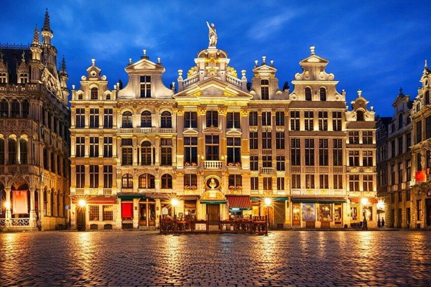 En historisk bygning med detaljeret arkitektur, en brostensbelagt gade og oplyste vinduer. 3