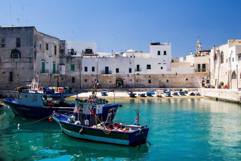 A harbor with boats, buildings, and clear blue water. 3
