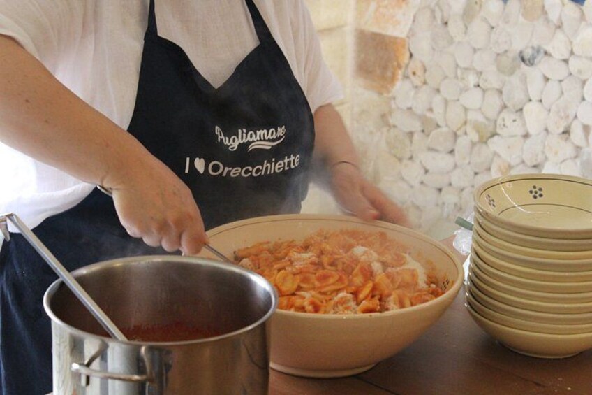 A person cooking pasta in a kitchen. 1