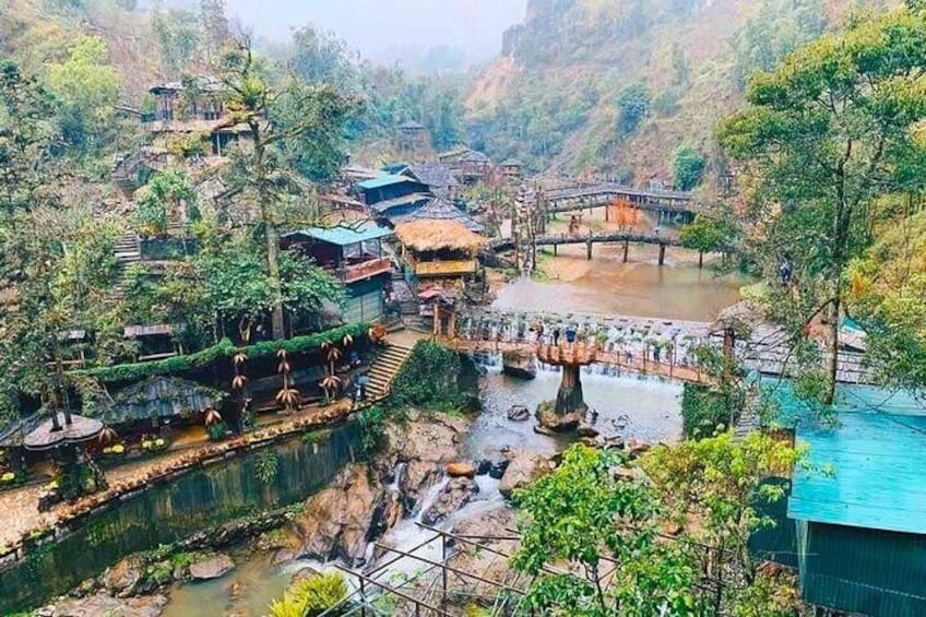 A river with bridges, a waterfall, and traditional houses surrounded by greenery. 2