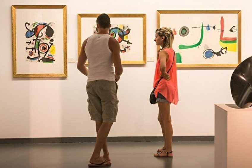 To personer betragter abstrakt kunst i et galleri. 3